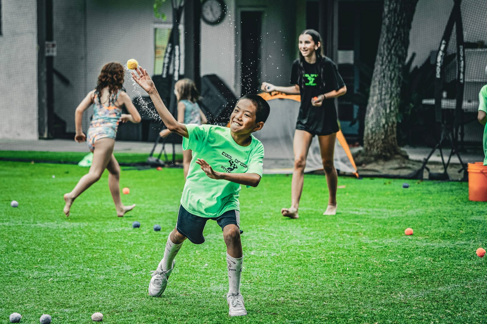 Kid mid-throw with water balloon at Cool Brook Sports Camp