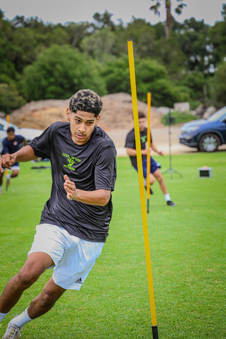 Athlete sprinting through agility poles