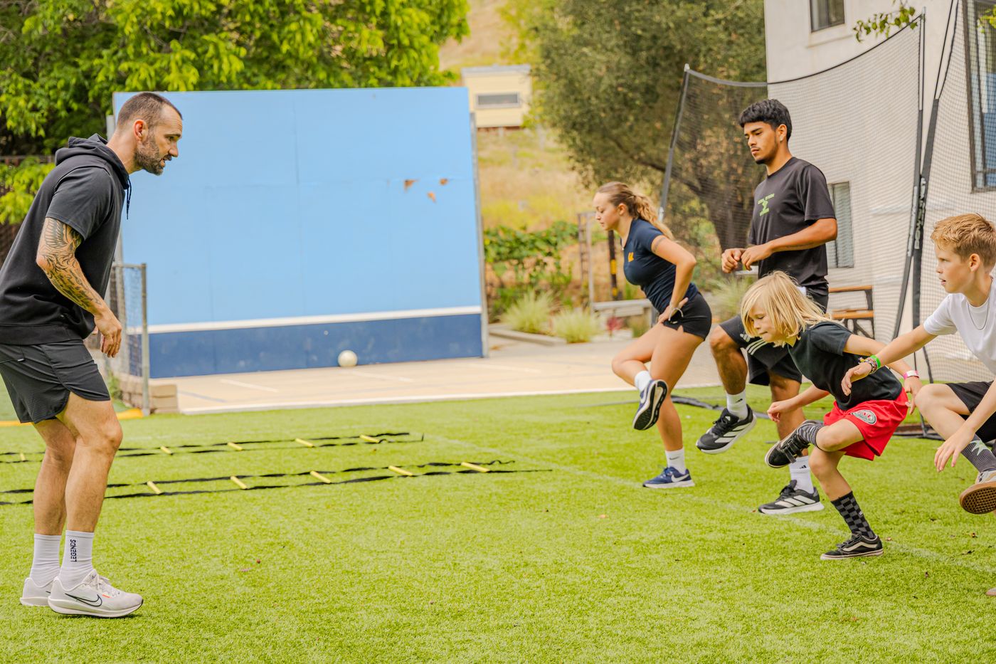 Young athletes running agility ladder drills