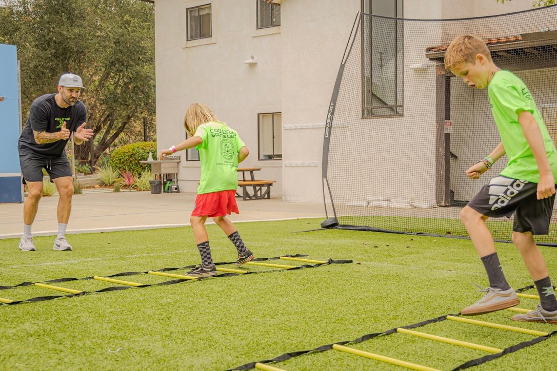 Kids working through agility ladders with coach