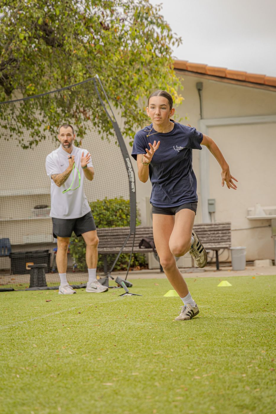Athlete sprinting with coach cheering